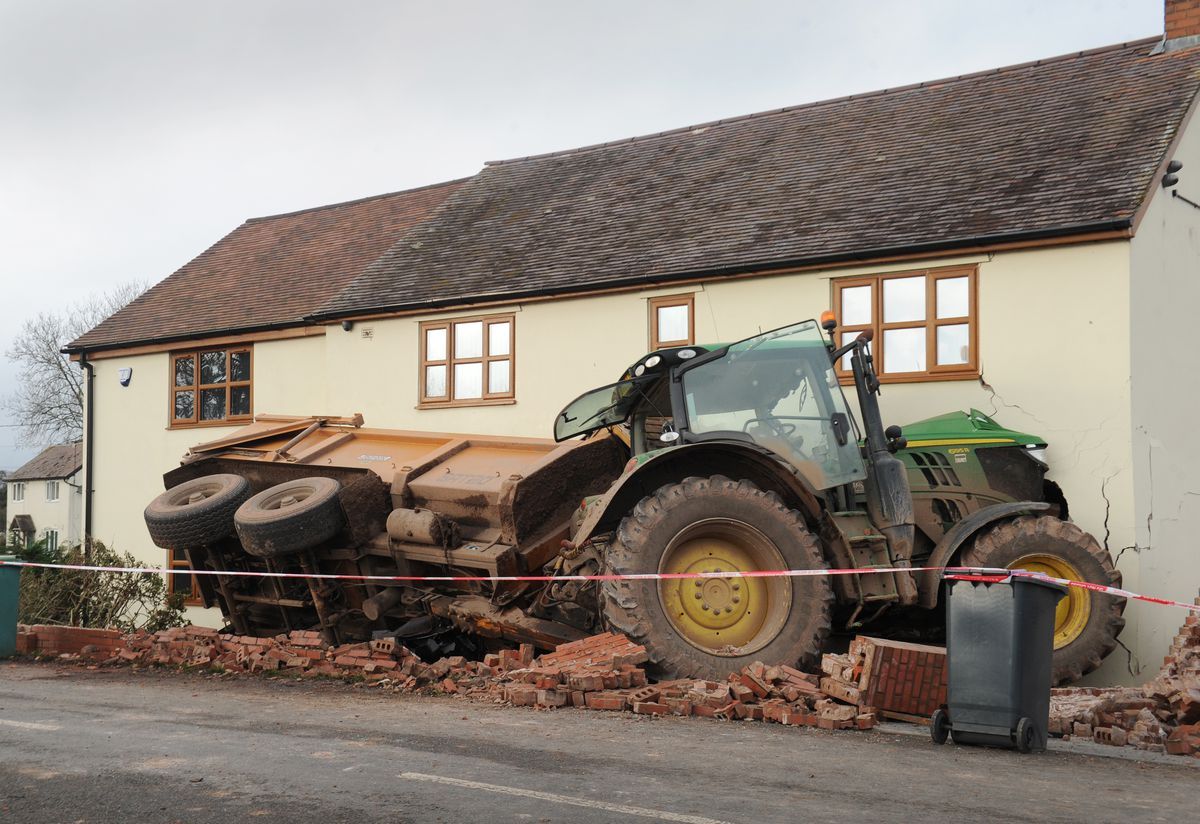 Tractor towing a trailer crashes through the front of a house