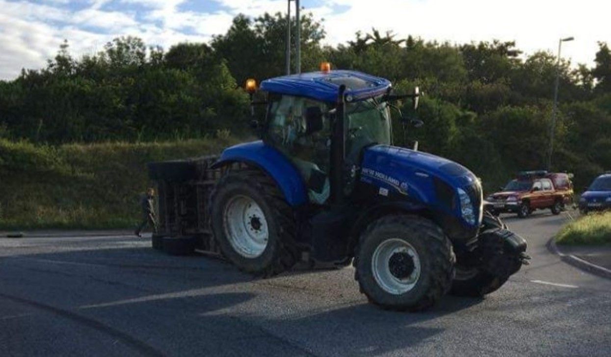 Livestock trailer carrying 12 cows overturns at roundabout